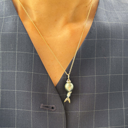 Tahitian pearl pendant with gold and diamond details on a gray suit jacket